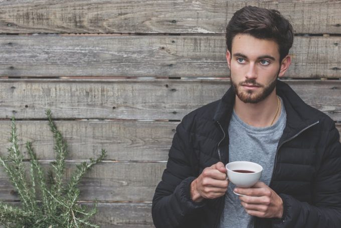 man wearing a jacket drinking tea