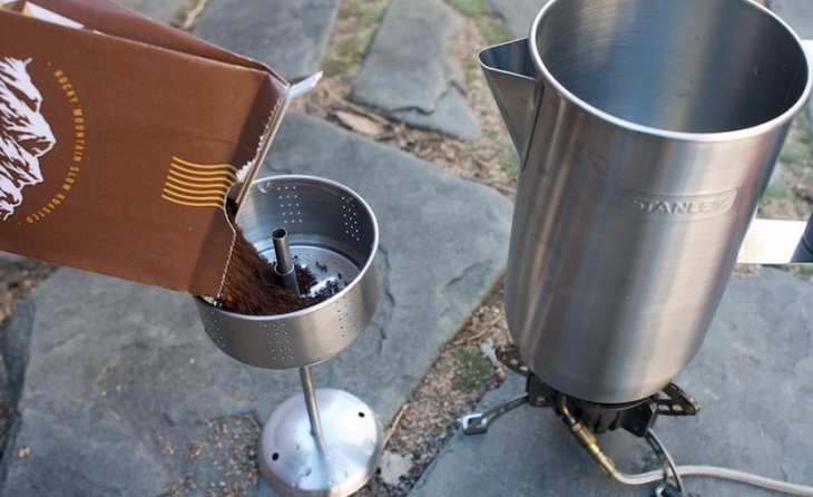 A persong making coffee with stanley coffee percolator