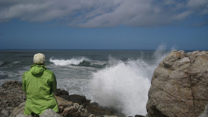 woman in rain jacket on beach