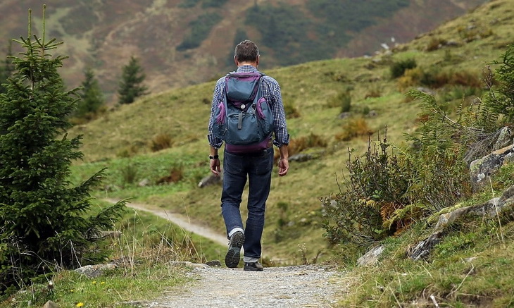 A man with a backpack hiking the mountains