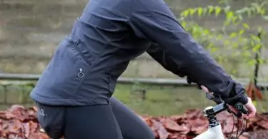 A womna on a bike wearing Rapha softshell jacket
