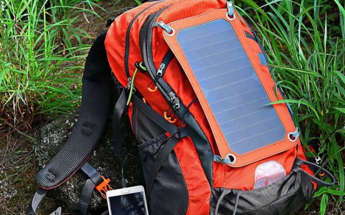 A solar backpack and a smartphone next to him