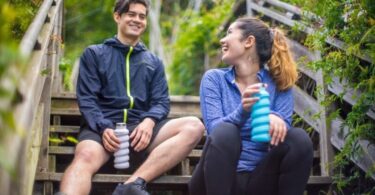 couple drinking water out of collapsibile water bottle