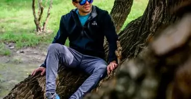 man siiting on a tree with softshell jacket