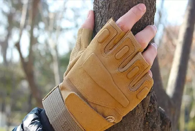 man with fingerless glove touching tree