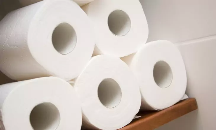 Five rolls of white toilet paper in a bath