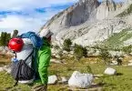A man with an ultralight backpack gear looking at the mountains