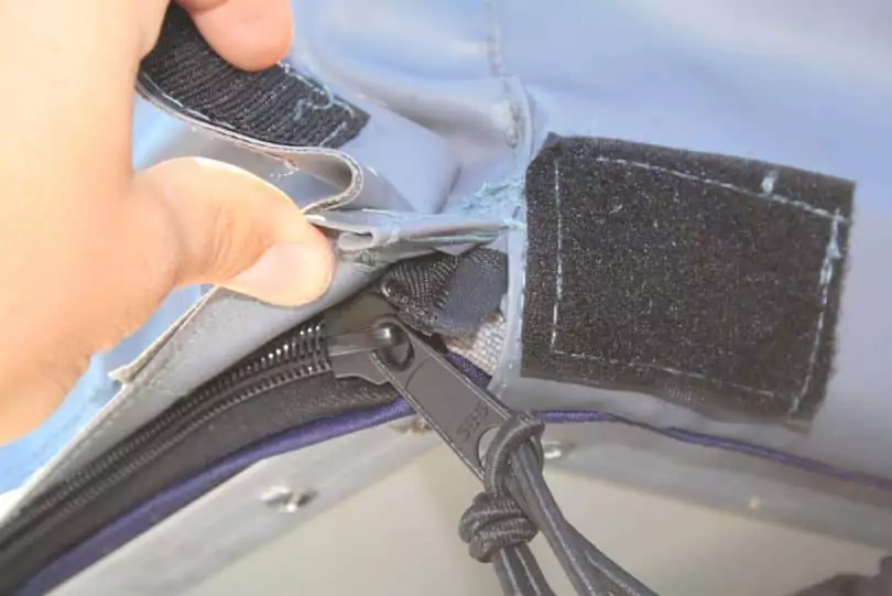 a man checking tent zipper