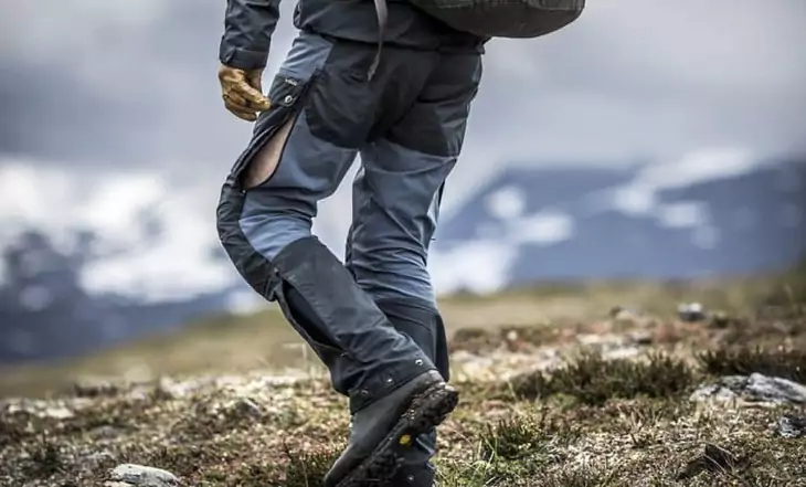 Man wearing a pair of rain hiking pants climbing the mountains