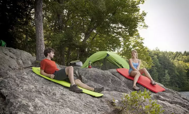 Two adults enjoying outside on sleeping pads