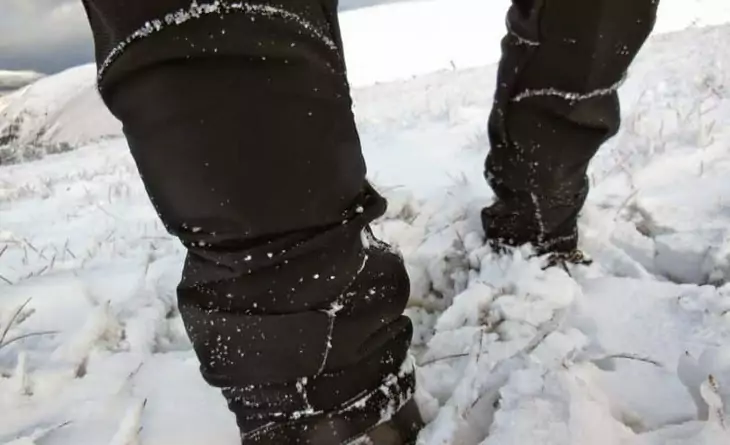 Image of a mans legs in the snow wearing a softshell hiking pants
