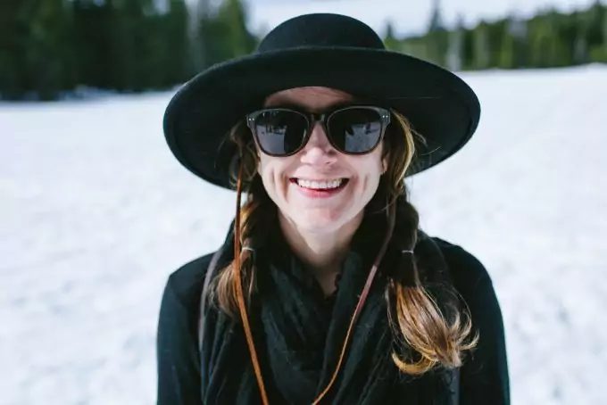 smiling-woman-with-hat-and-sunglasses-on-the-snow