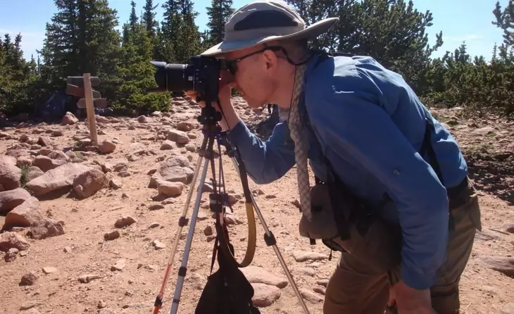 A man taking picture with his camera sitting on Universal TrailPix Trekking Pole Tripod