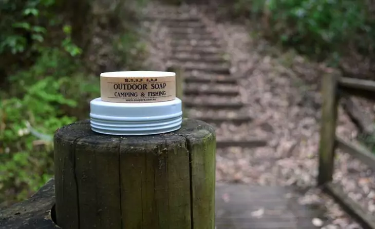 A camping soap sitting on a wood and some stairs on the background