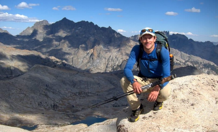 Image of a backpacker on top of the mountain