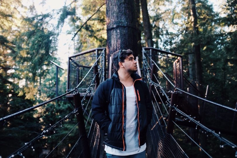 Man in Black Jacket Standing on Hanging Bridge