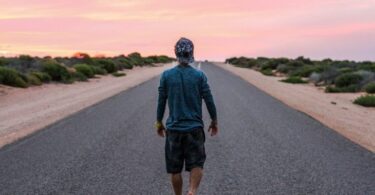 photo of a man hiking barefoot