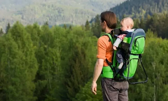 father carrying his little child in the nature