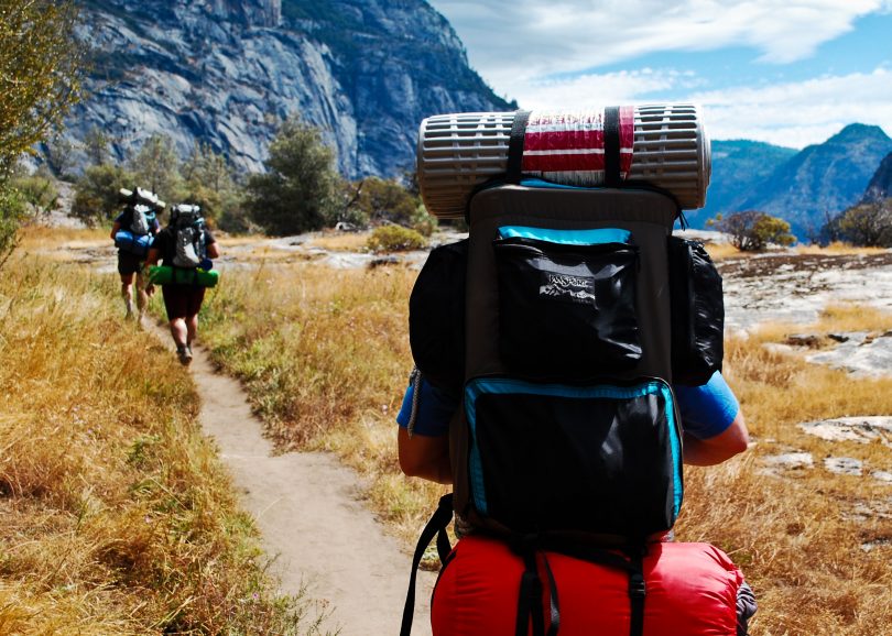 group of adults backpacking in the mountains