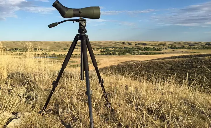 A photcamera on a tripod and a backcountry background