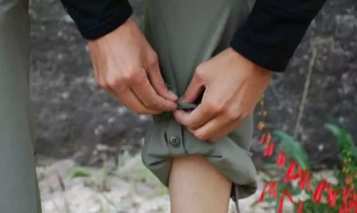 A woman rolling up her hiking pants
