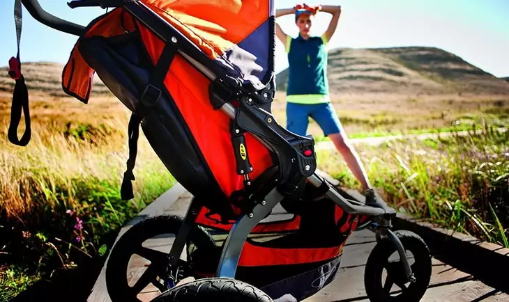 Image of a woman in front of a hiking stroller