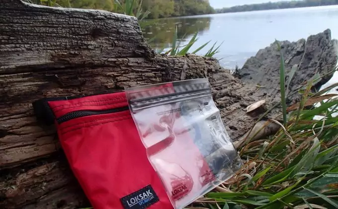 Image of Image showing Loksak Opsak waterproof bags on the ground near a water