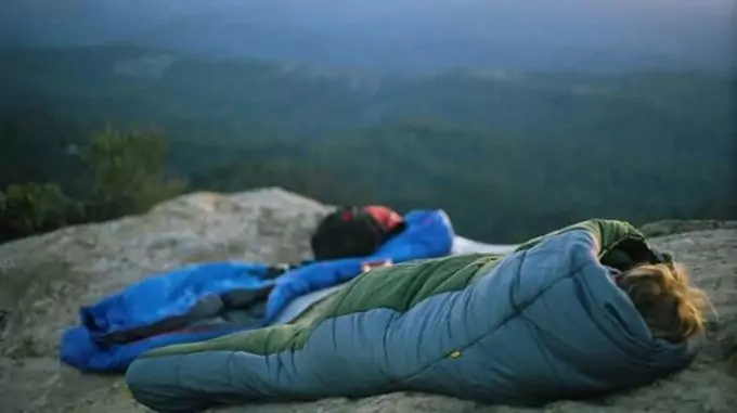 Image showing a woman sitting in a sleeping bag outside