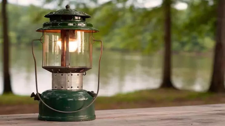 IImage showing a gas camping-lantern and a forest view