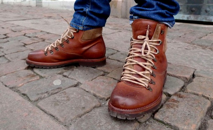 A MAN WEARING A PAIR OF HIKING BOOTS BY BRUNELLO CUCINELLI