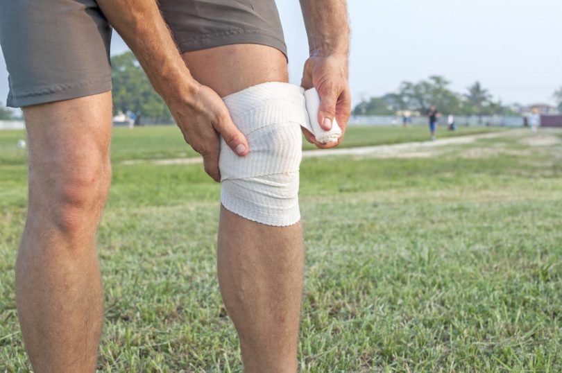 Man Wrapping a Knee With an ACE Bandage