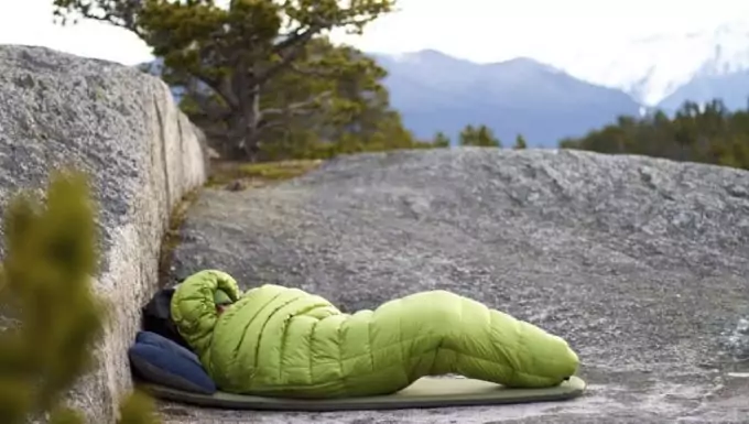a person sitting in a Mummy-Shaped-and-Cold-Weather-Sleeping-Bags