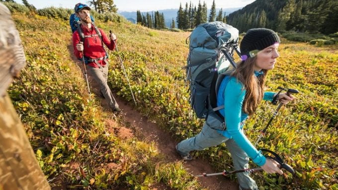 Image of two hikers with backpacks on a moutain road