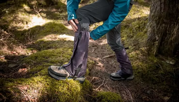 a-hiker-adjusting-their-gaiters-to-fit-properly