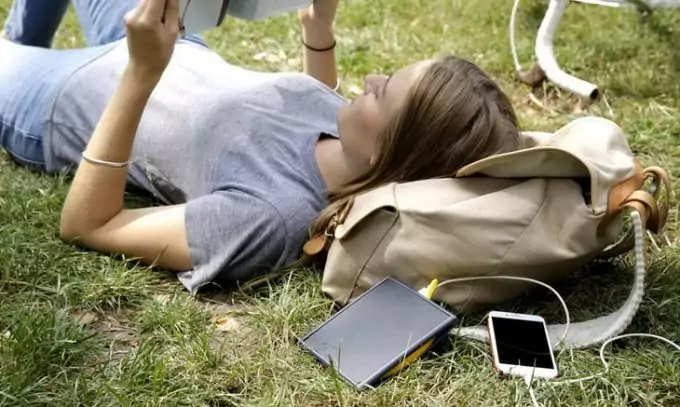 a woman relaxing on the grass reading a book