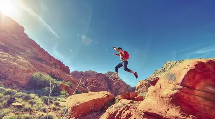 A man jumping from a rock to another