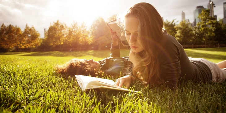 Two Young Women Readin In Park At Sunset