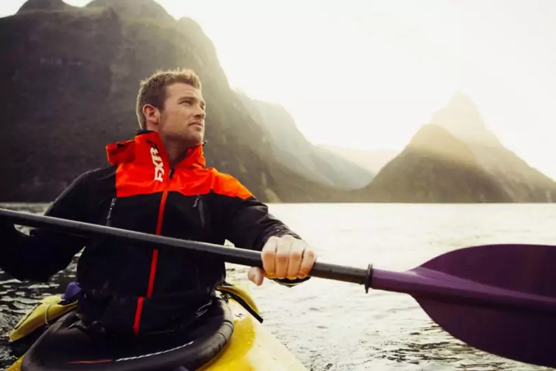 photo of a man in a canoe wearing windproof external shell