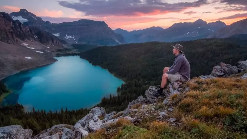 Person Sitting on Gray Rocks during Sunset