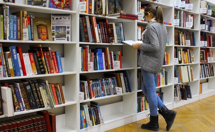 Woman Reading Book in a Bookstore