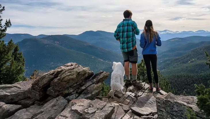 Young couple hiking with their dog