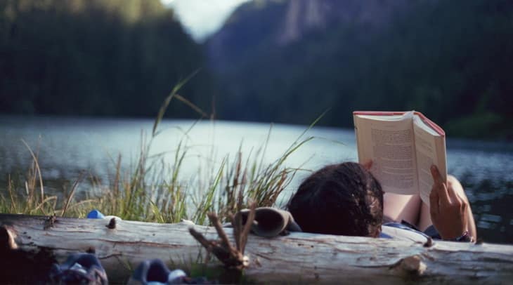 woman reading by lake