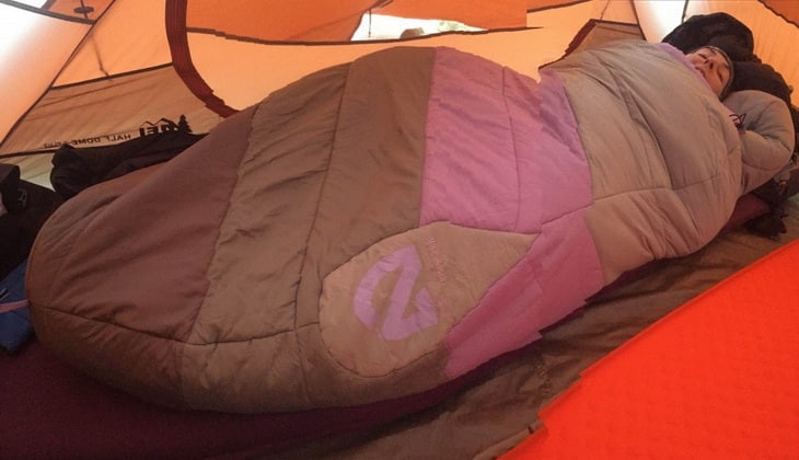 A woman in a Nemo sleeping bag in a tent