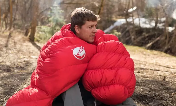 A man with Klymit KSB 20 Sleeping Bag on his shoulders