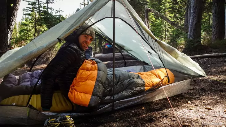 Man in a sleeping bag looking at the camera