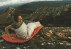 A woman sitting on Sea to Summit Ultralight Mat on top of the mountains