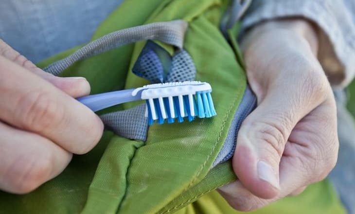Cleaning sleeping bag with a toothbrush