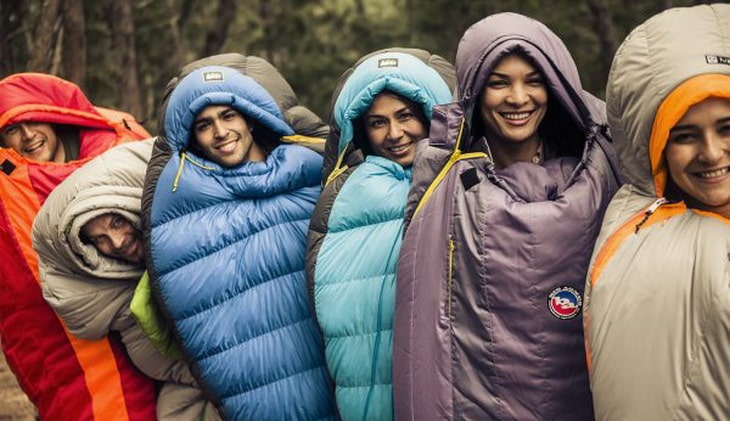 Group of people in sleeping bags taking a picture 