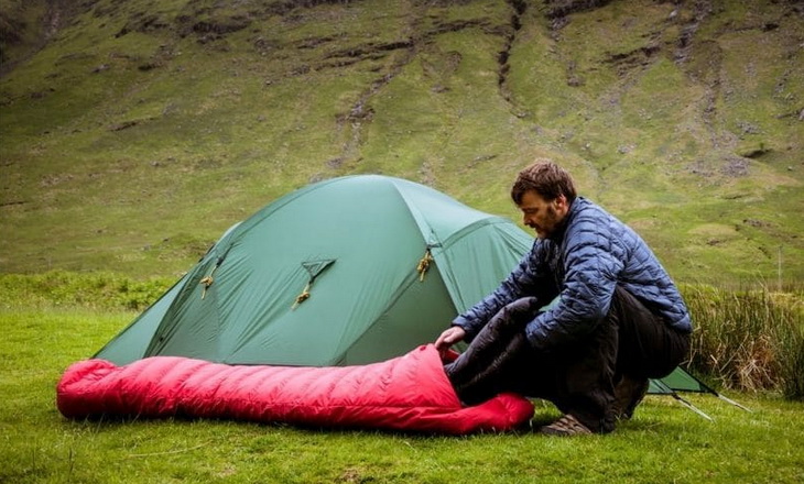 A man preparing-sleeping-bag-for-camping