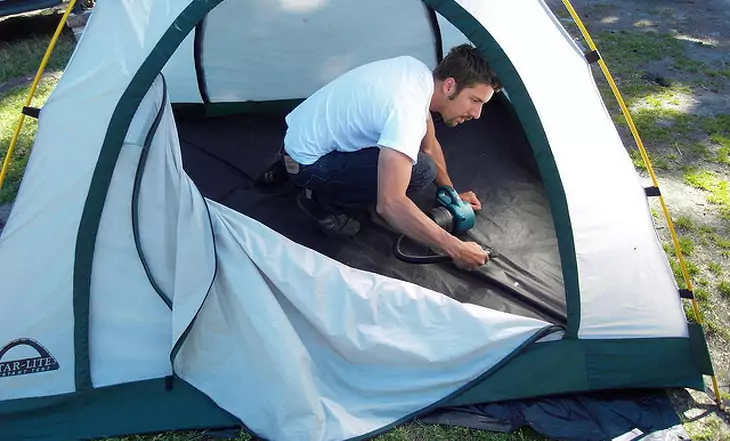 A man cleaning a tent